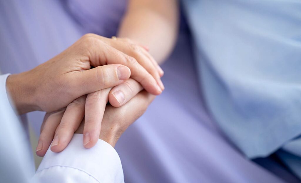 hospice and palliative patient holding hands